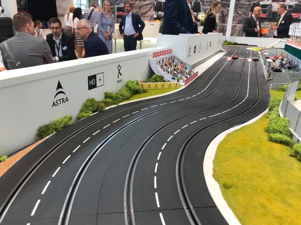 Miniatur-Rennstrecke mit Boxengasse und Tribüne auf einer Messe