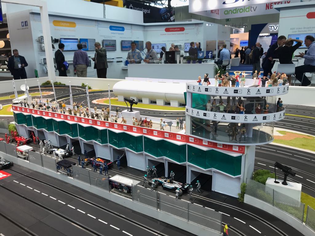 Miniatur-Rennstrecke mit Boxengasse und Tribüne auf einer Messe