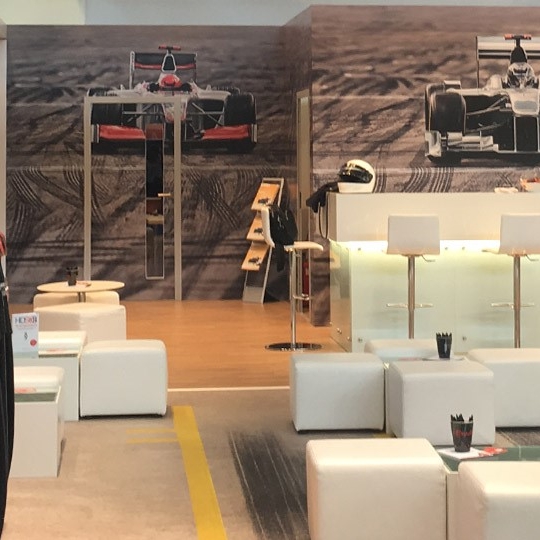 Messestand von ASTRA mit Werbeslogan für Ultra HD über Satellit und einem Formel-1-Boxenstopp-Motiv im Hintergrund