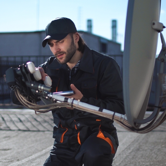 Eine Satellitenschüssel, die gewartet wird.