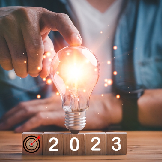 Eine Person berührt eine Glühbirne, die gerade leuchtet.