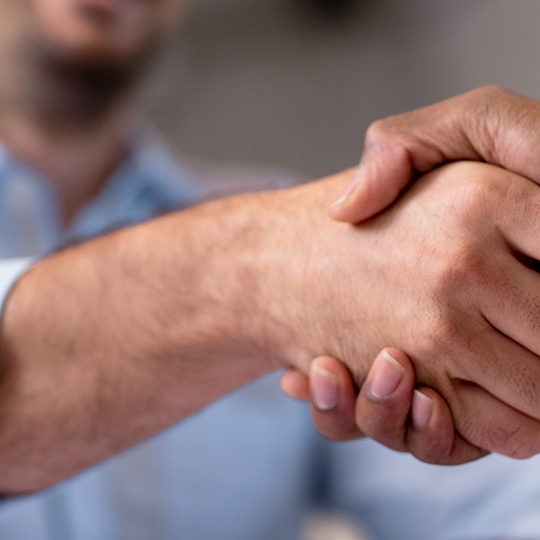 Zwei Personen schütteln sich die Hände.