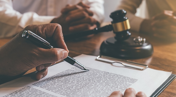 Eine Person liest ein Dokument vor dem Richter.