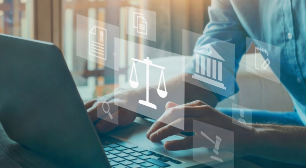 Jemand sitzt vor einem Laptop, umgeben von rechtlichen Symbolen.